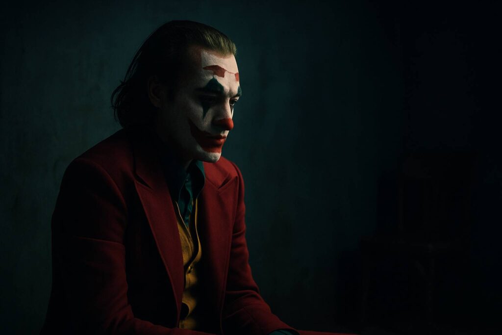The Joker isolated in darkness, symbolizing trauma and mental health struggles